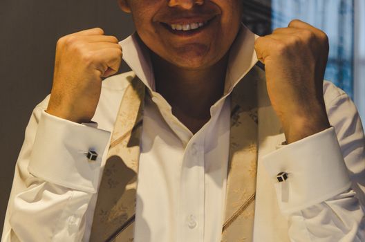 Groom arranging the sleeves of his shirt