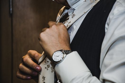 Groom adjusting his tie