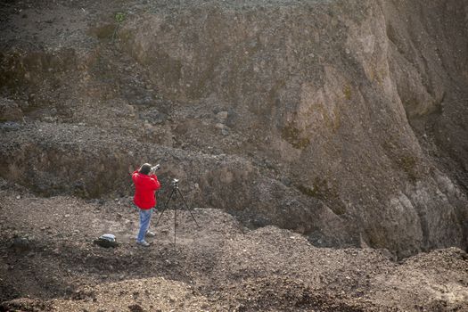 Nature photographer traveler taking photo of beautiful landscape. From top of the mountain.