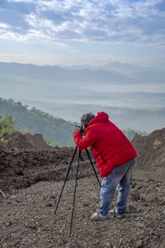 Nature photographer traveler taking photo of beautiful landscape. From top of the mountain.
