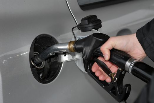 Male hand refilling the car with fuel on a filling station