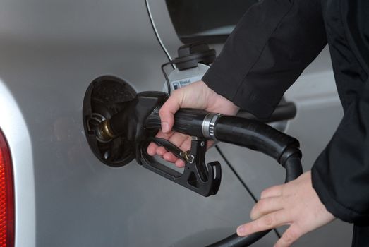 Male hand refilling the car with fuel on a filling station