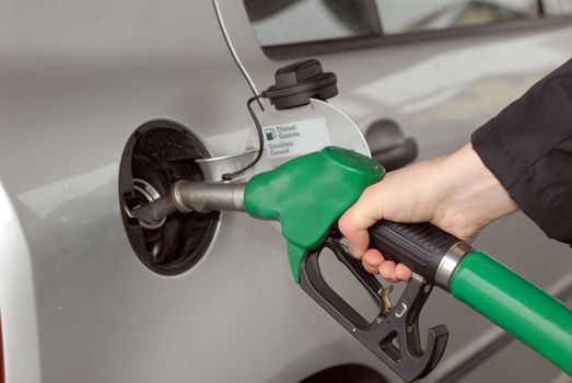 Male hand refilling the car with fuel on a filling station