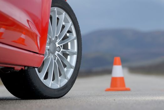 aluminium sport wheel on a red sport car and cone