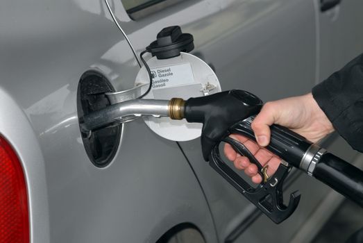 Male hand refilling the car with fuel on a filling station