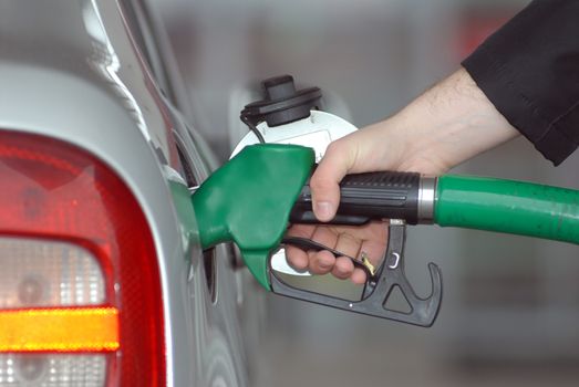 Male hand refilling the car with fuel on a filling station