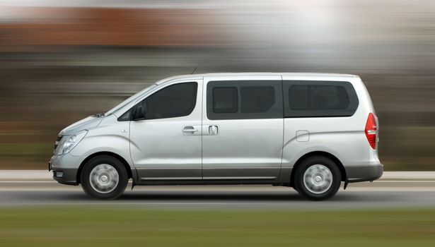 Fast moving white minibus on the road