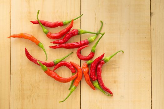 Red hot chili peppers on wooden background. Spicy chilli peppers.