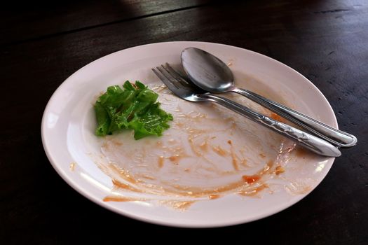 plate empty trash food and Leaves of green vegetables on a plate of rice, plate fork and spoon