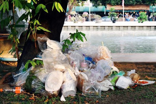 Waste plastic heap, Garbage plastic, Waste dump, Pile plastic bags and wet food waste at the the tree and river background, Polluting nature ecological