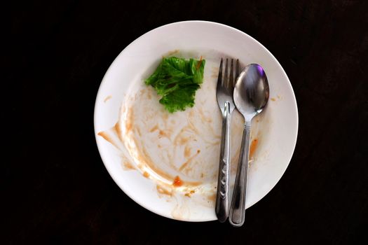 plate empty trash food and Leaves of green vegetables on a plate of rice, plate fork and spoon