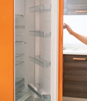 Woman open refrigerator door in the kitchen