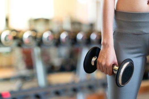 Close up women with dumbbells in hands the gym