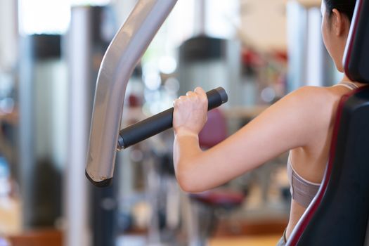 Women at the gym exercising on a machine.