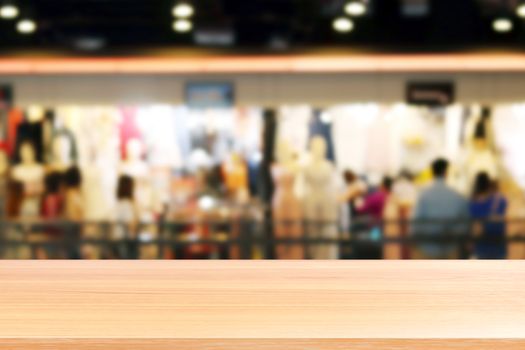 wood plank on blurred inside shopping mall and people walking shop, wood table board empty on clothing store fashion blur inside mall soft background