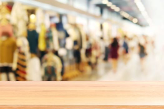 wood plank on blurred inside shopping mall and people walking shop, wood table board empty on clothing store fashion blur inside mall soft background