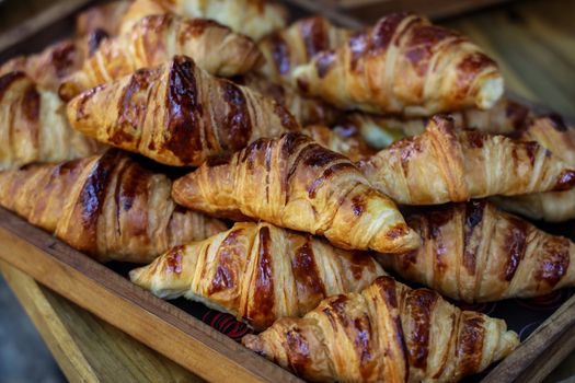 Delicious fresh croissants on wooden cutting board