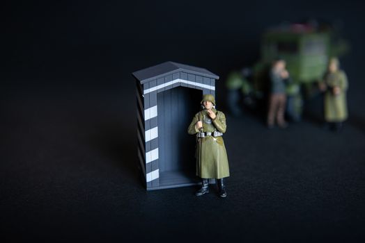 Toy a figure of a man in a military German uniform. In the background of a vague truck