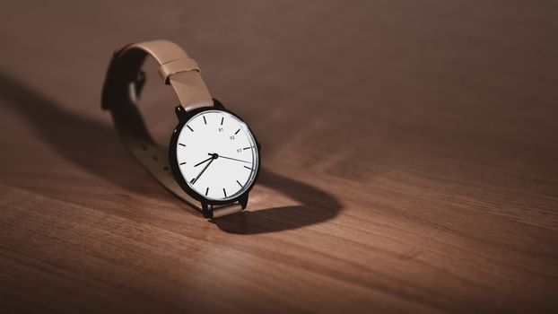 wristwatch on a wooden table with room for text