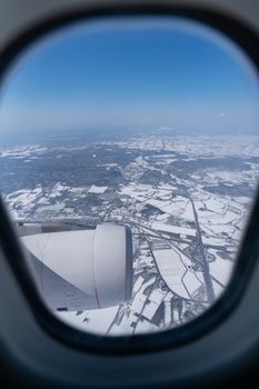 View of beautiful city covered by snow from a airplane window.