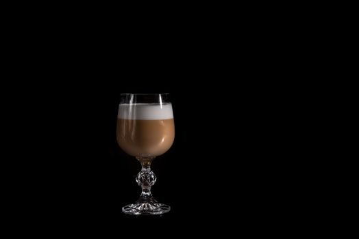 multilayer coffee or cappuccino in a glass cup on black background