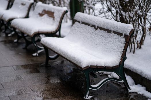 Frozen snow covered chair in winter park.