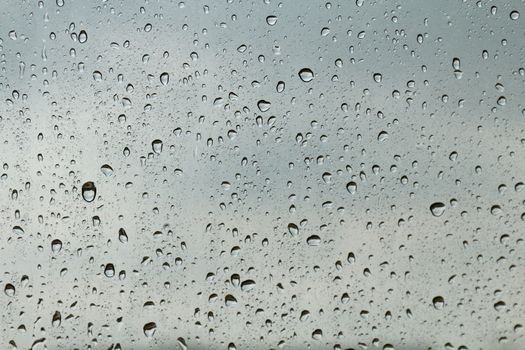 Water drop fresh condensation on window glass texture, rainy season wet background cooling feels and cold, raindrops texture wet transparent bubble