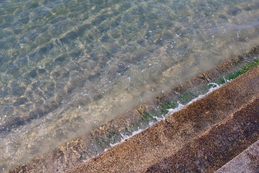 Clean water wave with cement stairs, Crystal clear sea waters and superb clean, See rocks on the bottom of the sea nature ocean, under water in beach clear and clean