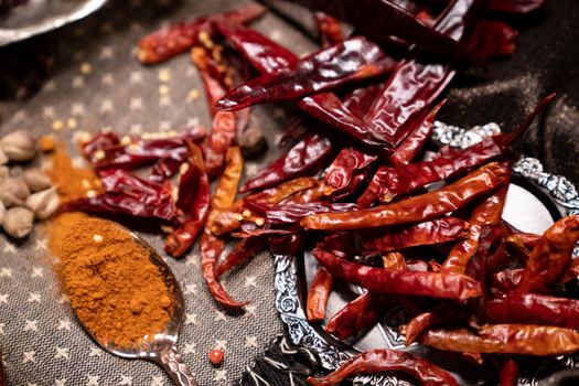 Dry red chillies and dried chilli powder on spoon.