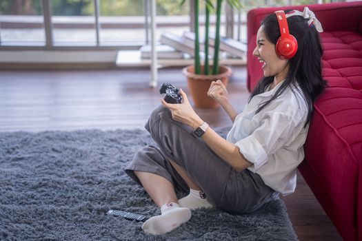 young asian woman enjoy her media gaming in the living room