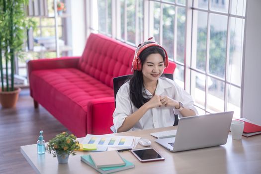 top view of young asian woman working with laptop computer in the living room. Work from home and study at home concept.