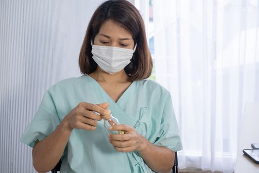 old asian patient wear surgical mask looking to drug bottle , she admit in hospital, she want to pollution protection and virus protection, elderly healthcare and infection control, corona virus