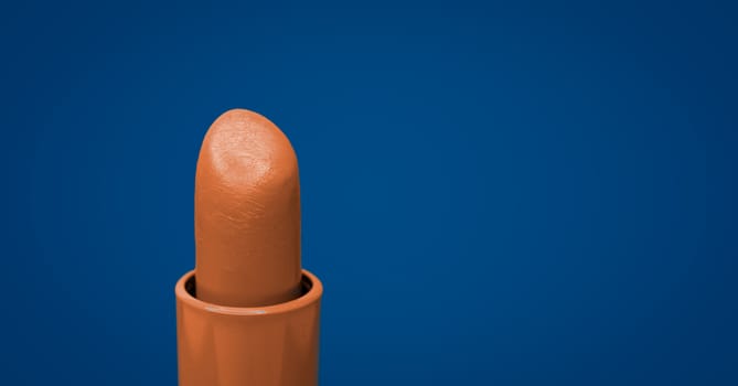 Beautiful bright orange lipstick and classic blue complementary color on the background background.