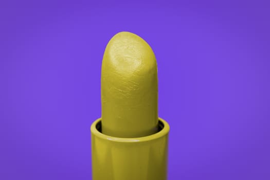 Beautiful bright yellow lipstick and purple complementary color on the background.