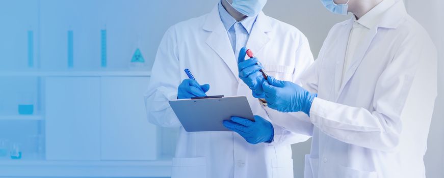 Covid-19 testing in laboratory. Scientists looking at blood samples of patients infected with Coronavirus disease 2019. Healthcare and medical banner background concept.