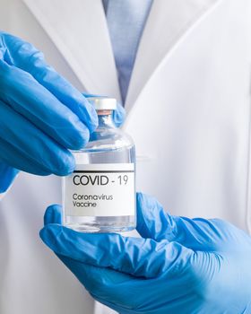 Bottle of coronavirus vaccine in the hands of doctors. Close up