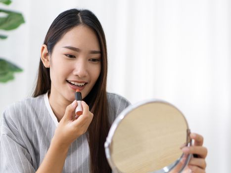 Young asian teen have fun learning to make-up in her room, enjoy leisure weekend at home.