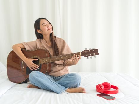 Teen playing guitar relax in bedroom, enjoy leisure weekend at home. Stress free concept.