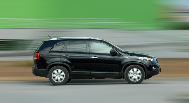 A panning shot of a speeding SUV