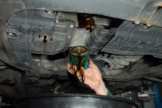mechanic in the hand, remove car oil filter