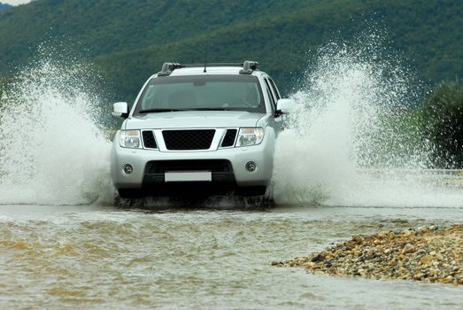 Suv splash on the river outdoor, traveling on the road