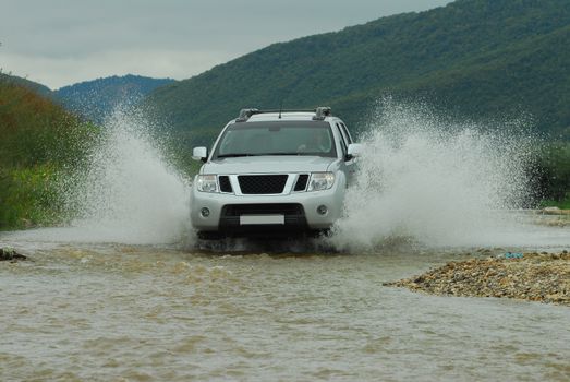 Suv splash on the river outdoor, traveling on the road