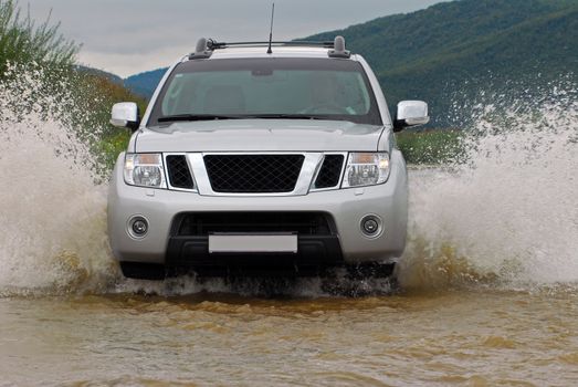 Suv splash on the river outdoor, traveling on the road