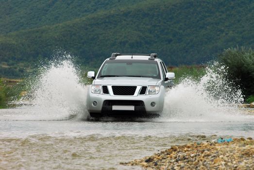 Suv splash on the river outdoor, traveling on the road