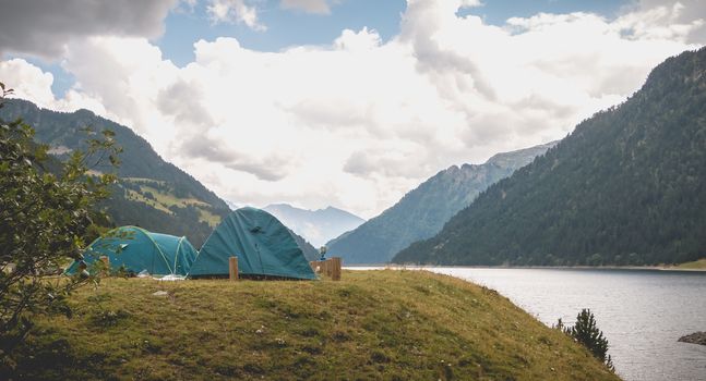 Wild camping atmosphere on a lake in the middle of the Pyrenees in France. with a tent, a gas rechaud