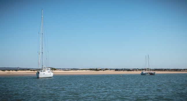 Tavira, Portugal - May 3, 2018: Sailing boat moored in the lagoons of the Ria Formosa Natural Park near the port of Tavira on a spring day