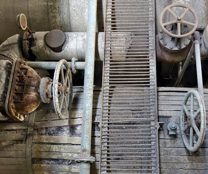 Old rusting machinery and valves in an abandoned factory