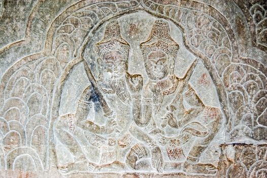 Bas relief carving of the Hindu gods Krishna and Shiva on a wall of the historic Angkor Wat temple in Siem Reap, Cambodia.