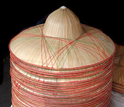 Handmade hats made from bamboo are on sale at an outdoor market