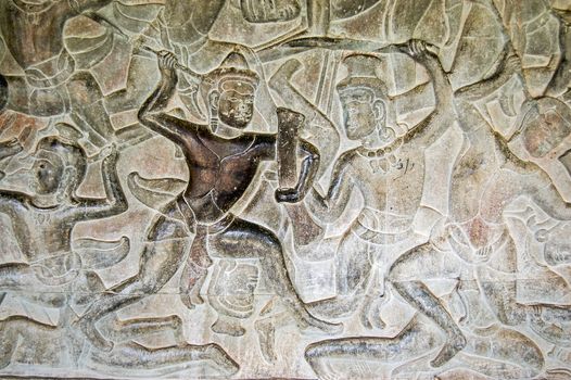 Ancient Khmer bas relief carving of gods fighting demons, devas versus asuras. Inner wall of the temple of Angkor Wat, Siem Reap, Cambodia.